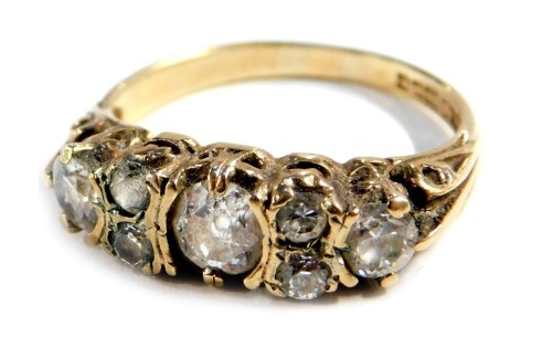 A 9ct gold diamond dress ring, set with seven imitation diamonds, possibly CZs, size N 1/2, 3g all in.