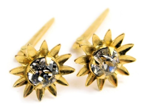 A pair of flower head design ear studs, yellow metal, set with white paste, stamped AJCD.