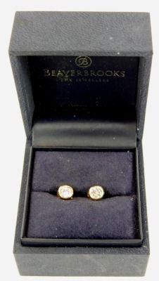 A pair of stud earrings, each with imitation diamond, in a rub over setting on single pin back with butterfly backs, yellow metal, marked 375, 0.8g all in, boxed. - 2