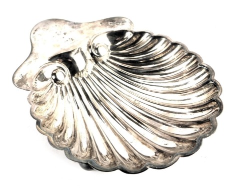 An Edward VII silver butter dish, of scallop shell form, raised on three ball feet, London 1902, 2.37oz, 10cm wide.