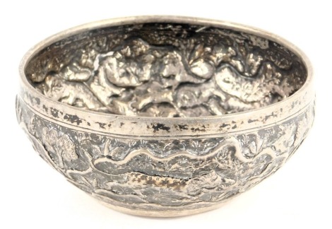 An Indian white metal bowl, repousse decorated with various animals, to include a tiger attacking an elephant, a lion attacking an animal, etc., 11cm diameter.