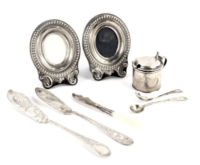 A group of small silver, to include an Edward VII silver mustard pot, with blue glass liner, a pair of silver mounted photograph frames, silver butter knives, salt spoon, etc., weighable silver 3.12oz.