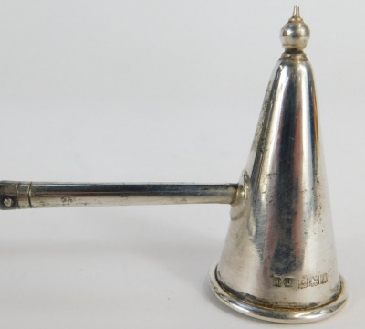 An Elizabeth II silver dish, of circular form inset with a commemorative Churchill 1965 crown, hallmarks rubbed, 2.57oz all in, 10cm diameter, together with a silver candle snuffer with turned handle, Birmingham 1968. - 2