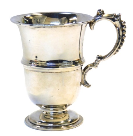 An Edward VII silver mug, the handle with raised beaded decoration, the body with a raised central band, on a circular stepped foot, Chester 1907, 2.97oz, 9.5cm high.