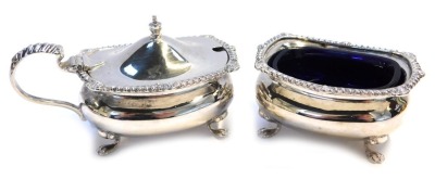 A George V silver part cruet, comprising open salt with blue glass liner, and lidded mustard pot, each of compressed bellied form raised on four paw feet, Birmingham 1926, weighable silver 4.55oz.