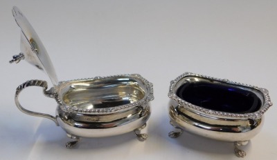 A George V silver part cruet, comprising open salt with blue glass liner, and lidded mustard pot, each of compressed bellied form raised on four paw feet, Birmingham 1926, weighable silver 4.55oz. - 2