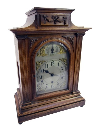 A late 19thC/early 20thC oak cased mantel clock, with a silvered Arabic numeric dial, with chime and silent, Westminster chime, 50cm high, 33cm wide, 19cm deep.