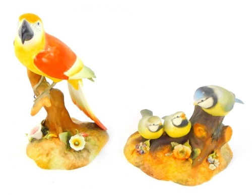 A Royal Crown Derby matt porcelain figure modelled a macaw, green printed marks, 18cm high, together with a Royal Crown Derby blue tit and chicks group, printed marks and signed to underside V Freestone, 11cm high.