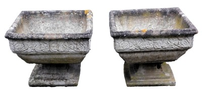 Two composition planters, of square form, decorated externally with floral motifs, on a stepped pedestal base, 40cm high, 50cm wide, 50cm deep.