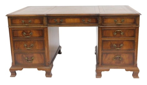 A Georgian style mahogany partner's desk, the gilt tooled brown leather top, over an arrangement to each side, of one long drawer flanked by four graduated drawer to the left, one drawer and a three dummy drawer cupboard to the ring, raised on ogee bracke