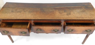 A late 18thC oak dresser, with three drawers, above a shaped apron, raised on ring turned legs, 76cm high, 161cm wide, 48.5cm deep. - 4