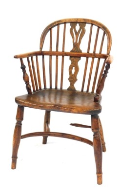 An early 19thC oak and elm Windsor chair, with a carved splat, solid saddle seat, raised on turned legs united by a crinoline stretcher, 54cm wide. (AF)