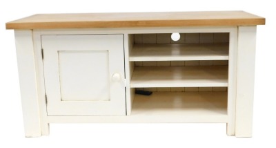 A modern pine television unit, the rectangular top above a moulded base with cupboard door flanked by three recesses, on stiles, 62cm high, 124cm wide, 48cm deep.