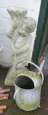 A composition garden statue, modelled as a cherub holding cornucopia, 74cm high, together with a galvanised metal watering can. (2)