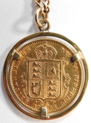 A Victorian shield back gold sovereign 1892, in halo mount and yellow metal chain, 12.1g all in. - 2