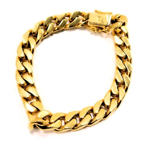 A heavy curb link bracelet, yellow metal stamped 18kt, 21cm long, 71.2g all in.