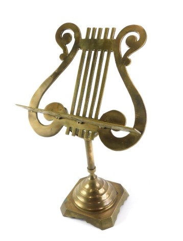 A small brass table top music stand, the lyre rest on a square base with canted corners, 50cm high.