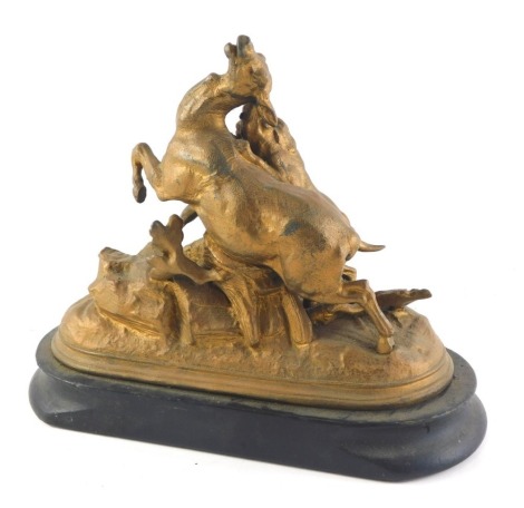 A late 19thC French gilt metal sculpture of a hound attacking a deer, on an ebonised base, indistinctly signed A. Dion, 27cm wide.