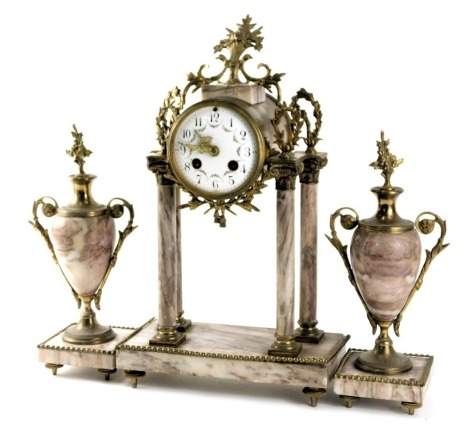 A late 19thC French portico clock garniture, the clock applied with gilt metal mounts, the white enamel dial decorated with swags, suspended on four rouge marble columns and a similar base on toupie feet, 41cm high, and two similar urns, each 38cm high.