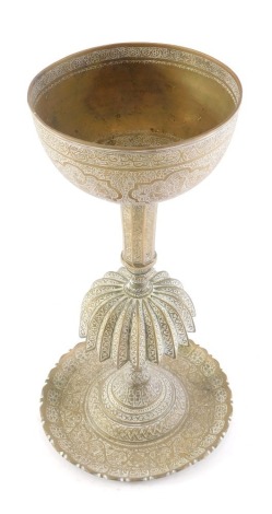 A late 19th/early 20thC Indian brass chalice, with engraved decoration figures within shaped cartouches, on a tapering column with domed central section and a domed foot, 31cm high.