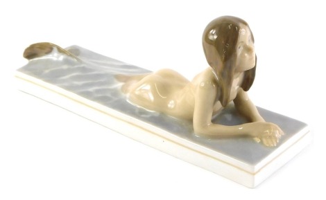 A Royal Copenhagen porcelain figure of a mermaid, printed and handwritten marks to underside, numbered 1212, 19cm long.