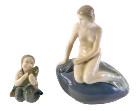 A Royal Copenhagen figure of a mermaid seated on a rock, 14cm high, and a smaller figure of a young mermaid with fish. (2)