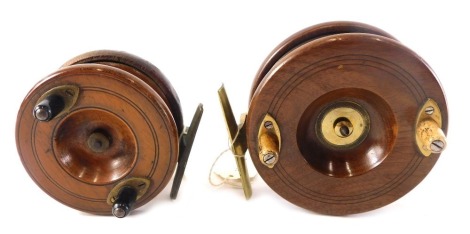 A mahogany and brass fishing reel with bone handles, 11.5cm diameter, and a smaller similar example. (2)