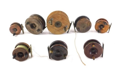 A collection of various mahogany and brass fishing reels, the largest 13cm diameter, the smallest 6cm diameter.