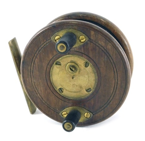 A mahogany and brass fishing reel with star back, 9cm diameter.