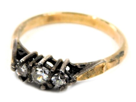 A three stone dress ring, set with three white paste stones in claw setting, on a gold coloured band stamped sil, ring size P½, 2.4g all in.