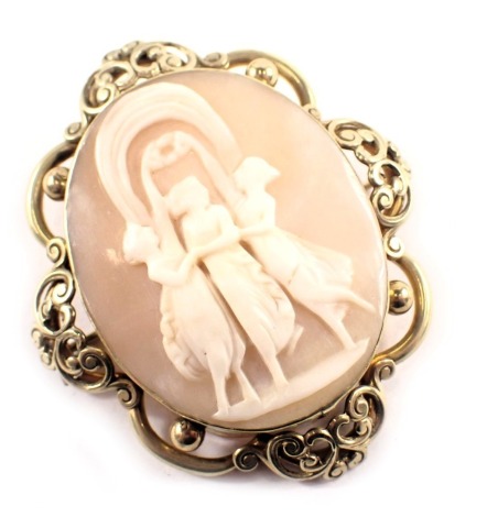 A 19thC shell cameo brooch, the oval plate with three maidens in flowing dress, with an arched Pinchbeck type frame, with safety chain and single pin back, yellow metal unmarked, 4.5cm x 6cm, 20g, boxed.