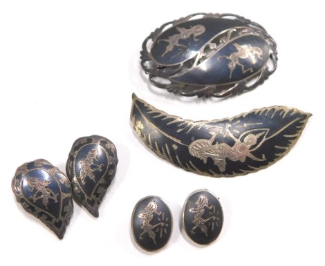 A group of Middle Eastern jewellery, comprising an oval twist design brooch with Nepalese style figures marked 925 Siam and sterling, 6cm diameter, and two pairs of clip on earrings in Niello design, 26.2g all in.