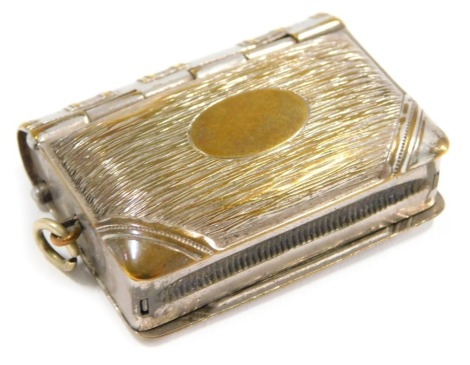 A novelty coin case, formed as a book with brushed detail, stainless steel, with match strike, 5cm high.