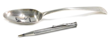 A Victorian silver fiddle pattern serving spoon, bearing lion crest, maker TC, London 1818, and a JM & Co silver cased pencil, 3oz gross. (2)