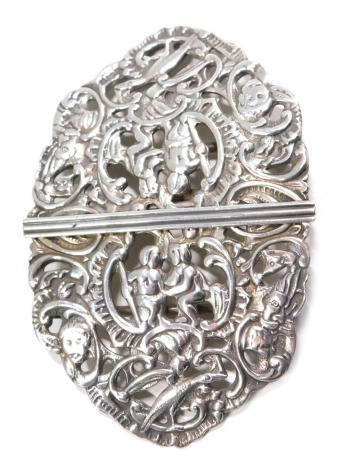 An Edwardian white metal nurse's buckle, heavily decorated with figures, birds and scrolls, Birmingham 1905, 9.5cm wide, 1.70oz.