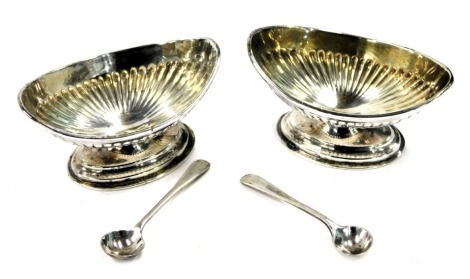 A pair of Victorian Coburn & Co silver salts, each with reeded design and later preserve spoons, London 1899, 2.50oz, in fitted case.