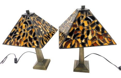 A pair of Tiffany style table lamp, each with a bronze effect base, and a stained glass square shade decorated with leaves within leaded borders, the shade 27cm wide.