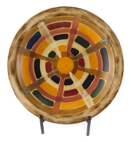 A large studio pottery charger, decorated with multicoloured design within a cream border, unmarked, 50cm diameter.