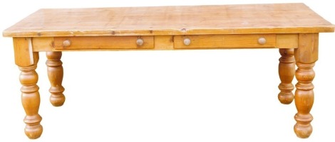 A pine farmhouse table, with a planked top above two frieze drawers, on turned legs, 78cm high, 210cm wide, 90cm deep.