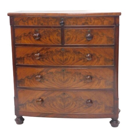 A Victorian mahogany bow front chest, of a single drawer over two short and three long graduated drawers, with knob handles and turned feet, 112cm high, 107cm wide, 54cm deep.