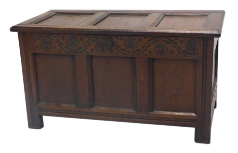 A 17thC oak coffer, with three panelled top, arabesque carved frieze, raised on stiles, 54cm high, 100cm wide, 50cm deep.