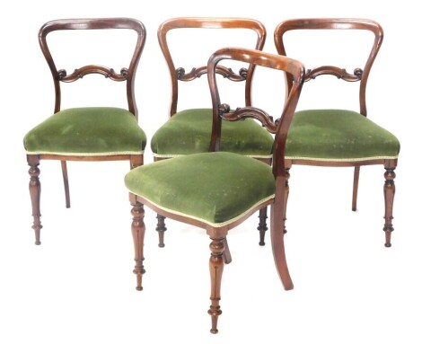 A set of four Victorian rosewood balloon back dining chairs, with serpentine seats and tulip carved four legs.