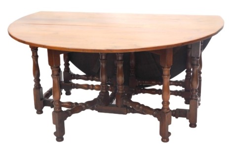 A 20thC yew gate leg dining table, in 17thC style, 160cm long x 175cm fully open.