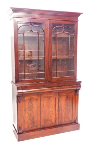 A Victorian mahogany cabinet bookcase, with moulded cornice, two astragal glazed doors over two flamed cushion drawers and three door cupboard base, on plinth, 225cm high, 125cm wide, 49cm deep.