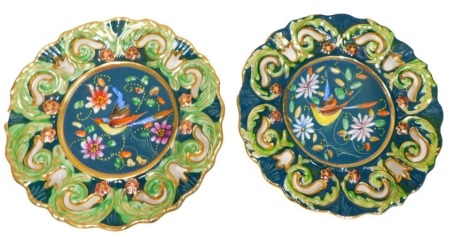 A pair of Belgian Faience and enamelled wall plates, with pierced borders and central ornithological reserves, 34cm diameter.