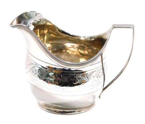 A George III silver cream jug, of helmet form, bright cut engraved with a band of flowers and scrolls above an initialled cartouche, London 1805, 2.66oz, 9cm high.