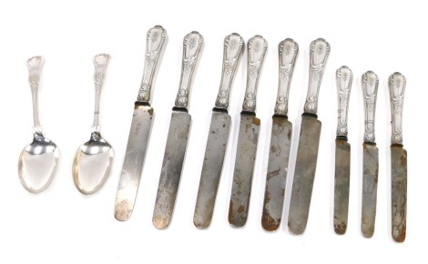 A set of six 19thC dinner knives, each with a plated handle cast with scrolls, initial engraved, together with three similar dessert forks and two King's pattern silver plated tablespoons.