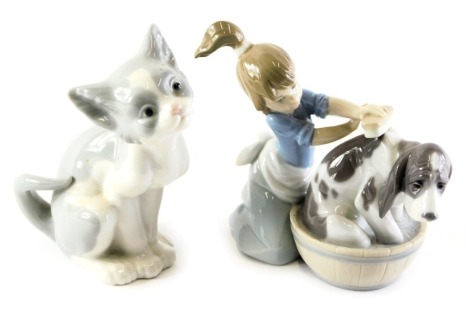 A Lladro porcelain figure group modelled as a young girl washing dog in bathtub, printed marks, 12cm high, and a cat, 14cm high.