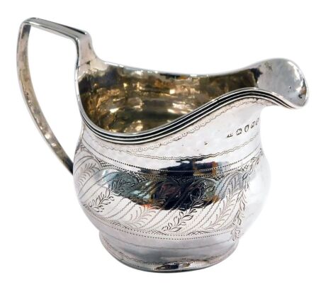 A George III silver cream jug, of helmet shaped form, with bright cut decoration, London 1807, 2.87oz, 8.5cm high.