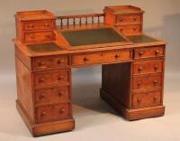 A 19thC oak bank clerks desk with raised writing slope and spindle gallery